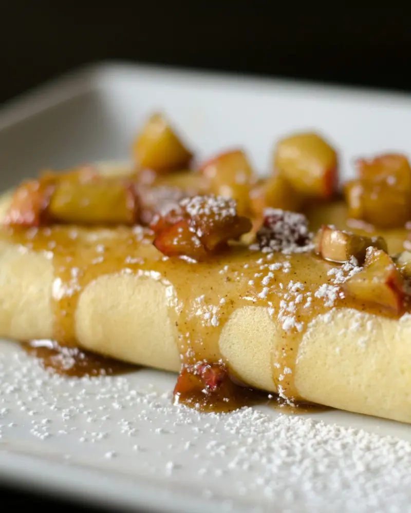 Crêpe aux pommes caramélisées, saupoudrée de sucre glace