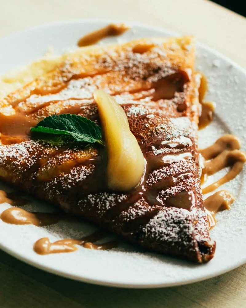 Crêpe pliée en triangle, nappée de sauce à l'orange caramélisée