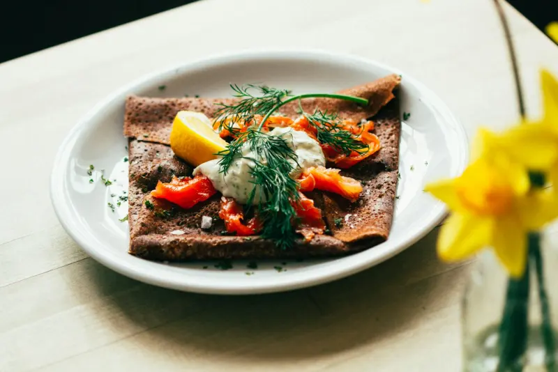 Galette de sarrasin garnie, œufs de poisson et aneth, jonquille en arrière-plan