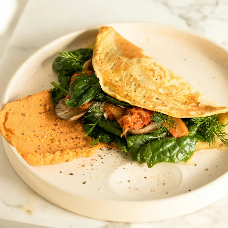Crêpe aux épinards et sauce tomate, servie sur marbre